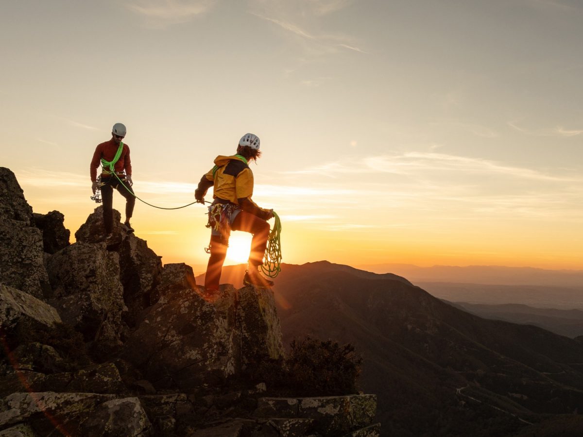 Bergsteiger bei Sonnenaufgang auf einem Gipfel