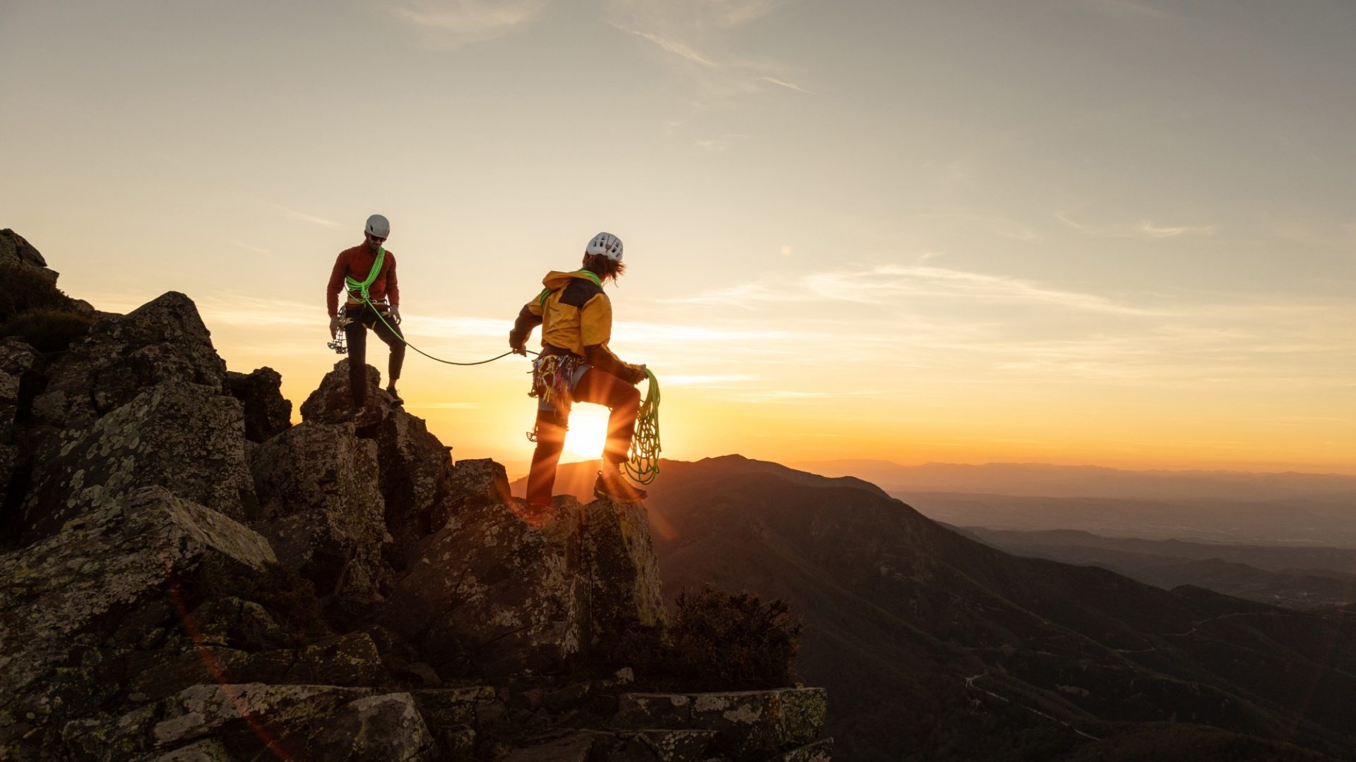 Bergsteiger bei Sonnenaufgang auf einem Gipfel
