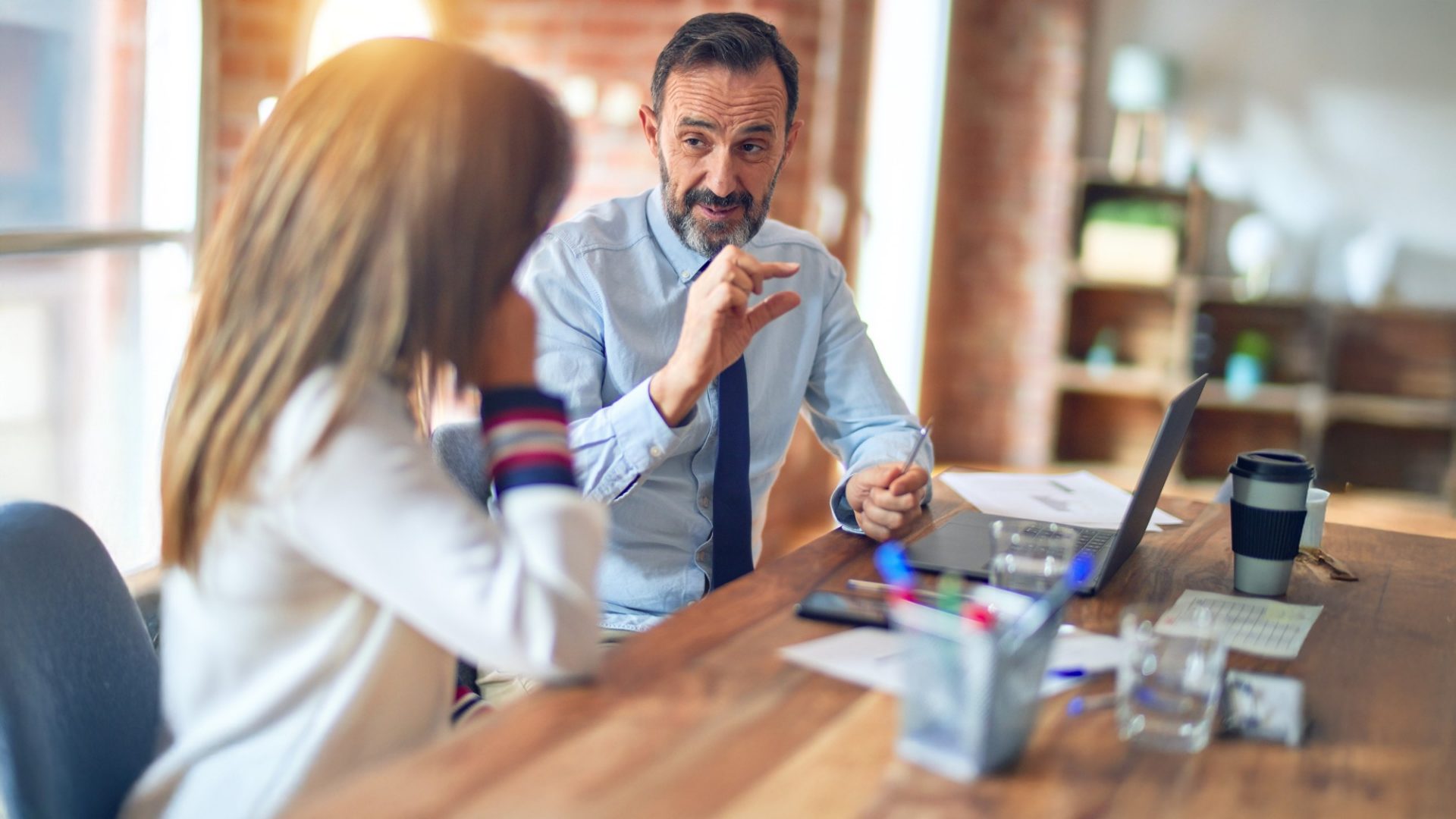 Mann erklärt einer Frau etwas am Laptop