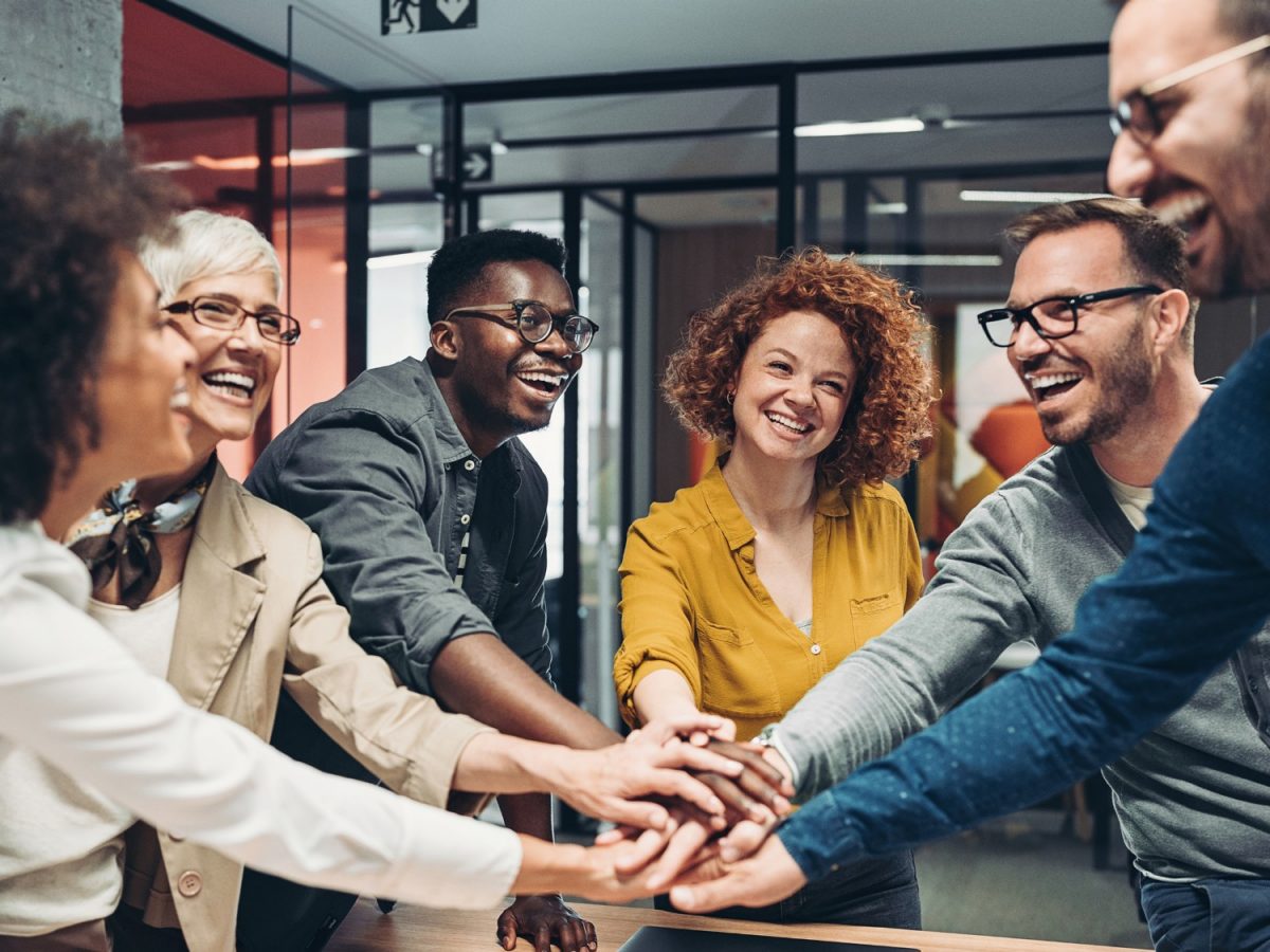Eine Gruppe junger Leute halten ihre Hände in die Mitte