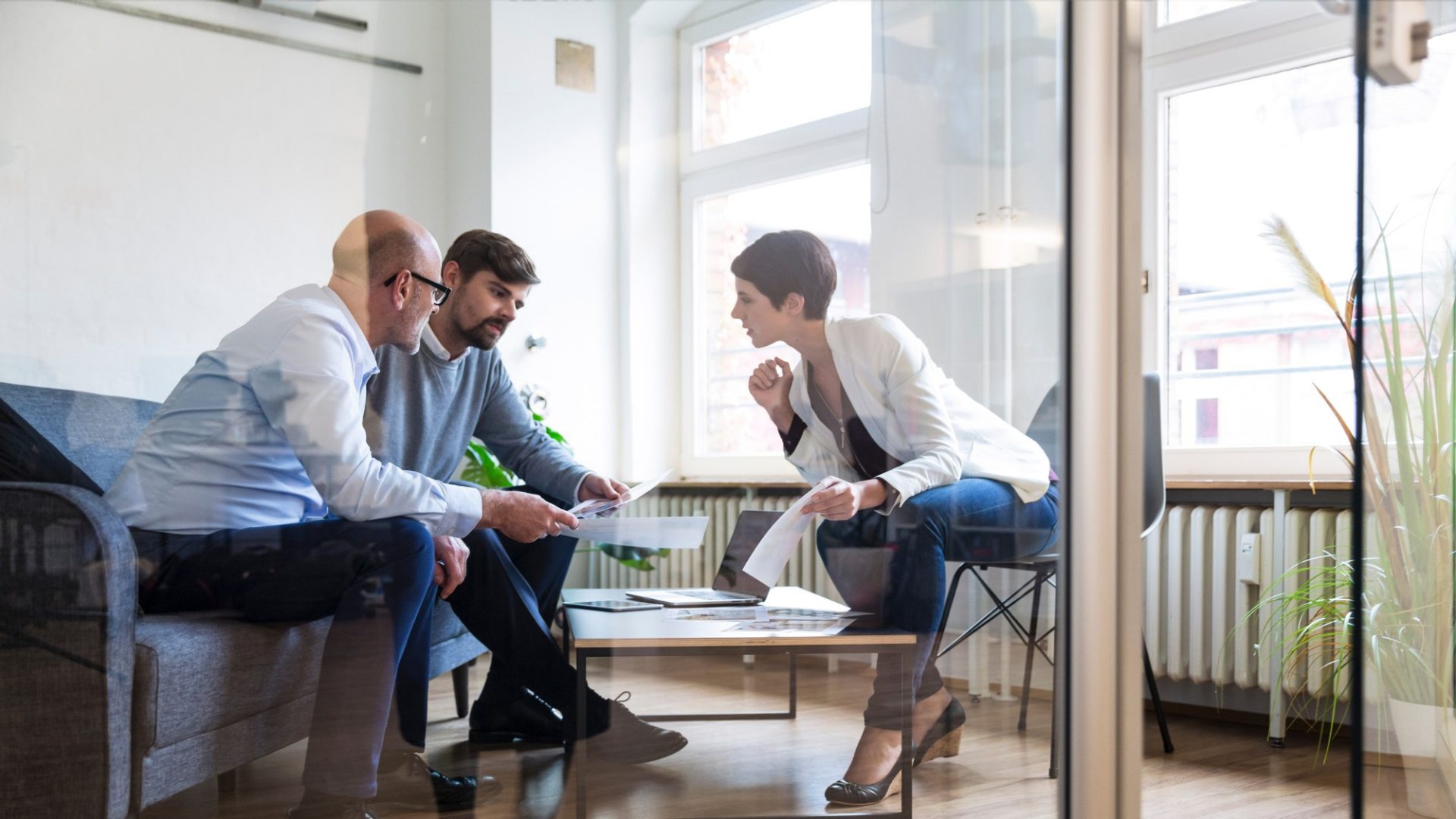 Drei Personen schauen sich ein Dokument an