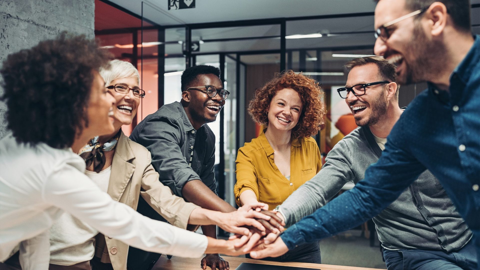 Eine Gruppe junger Leute halten ihre Hände in die Mitte