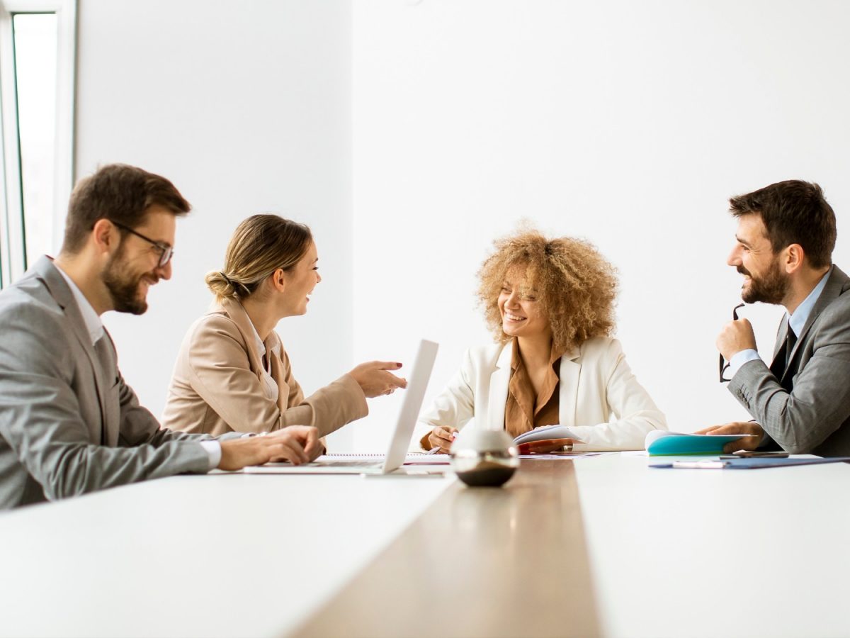 Männer und Frauen diskutieren an einem Tisch