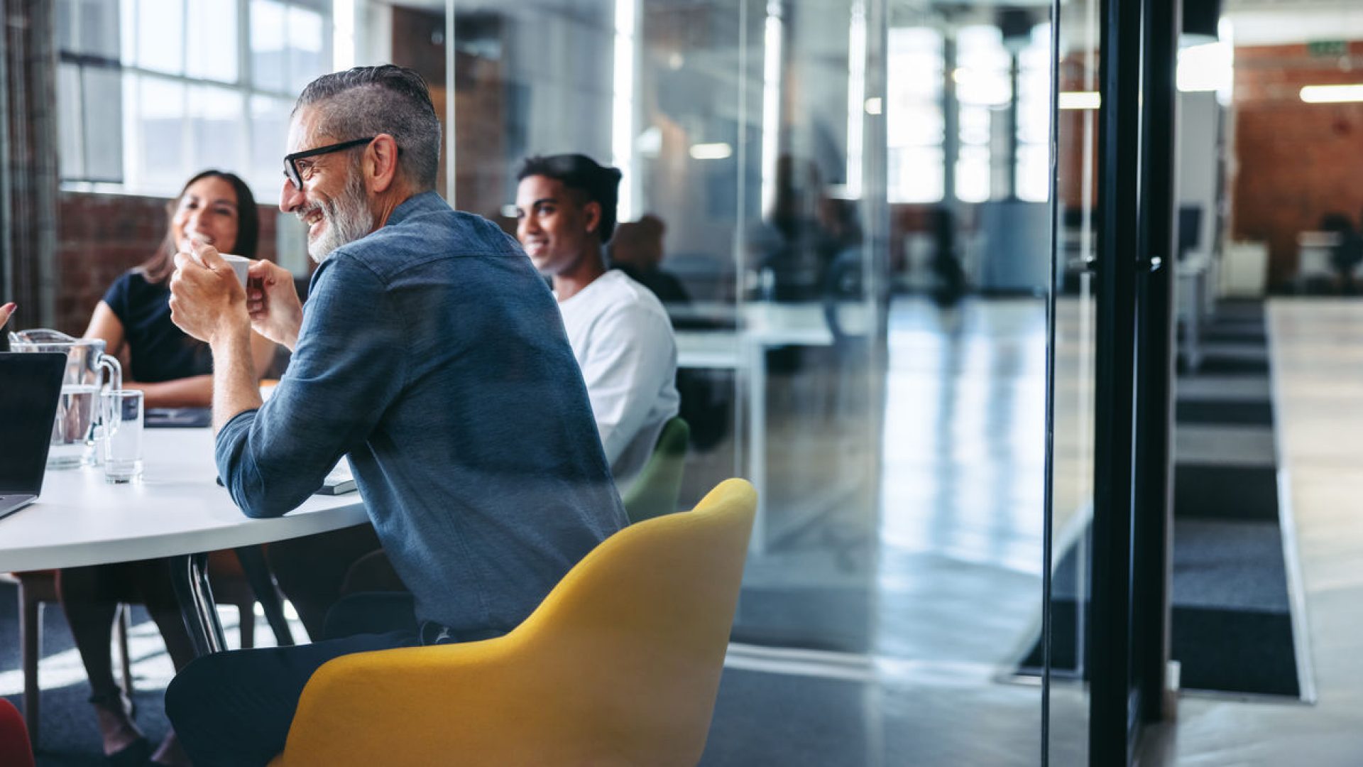 Cheerful businessman attending a meeting with his team